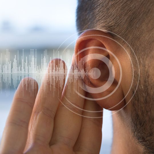 orelha de um homem com ondas de &aacute;udio a entrar no ouvido
