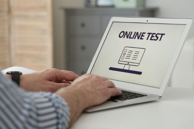computador port&aacute;til sobre uma mesa com um teste online no ecr&atilde;