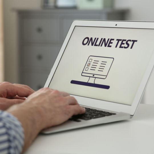 computador port&aacute;til sobre uma mesa com um teste online no ecr&atilde;