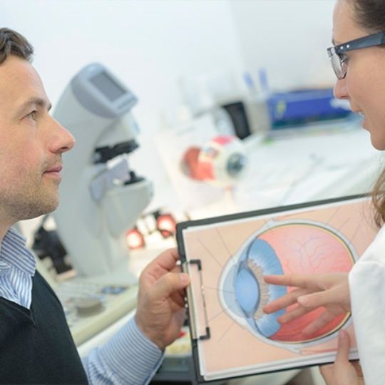 Oftalmologista a explicar a um homem o que é a tensão ocular