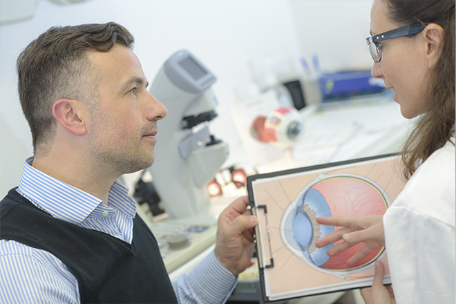 Oftalmologista a explicar a tensão ocular a um homem